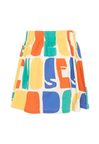 Jupe avec taille élastique présentant des formes abstraites colorées en blocs de jaune, orange, bleu et vert sur un fond blanc.