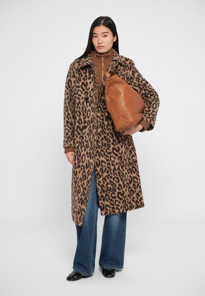 Cappotto maculato di leopardo con colletto, chiusura a bottone e spacchi laterali. Abbinato a un top marrone a costine e pantaloni in denim blu a gamba larga. Borsa in pelle marrone.