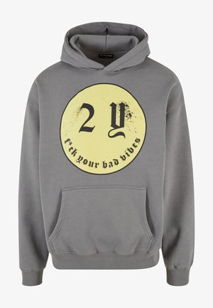 Hallitus halli pusa, millel on esipocket ja suur ümmargune kollane graafika, millel on musta värviga tekst "2Y" ja "f*ck your bad vibes".