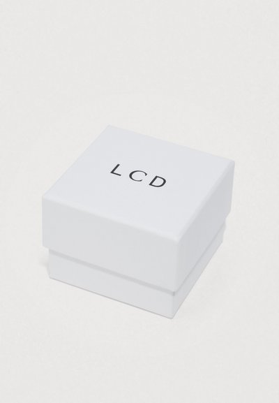 Λευκό τετράγωνο κουτί με λείο φινίρισμα, με τα γράμματα "LCD" τυπωμένα μαύρα στην κορυφή. Συμπαγές σχέδιο με αποσπώμενο καπάκι.