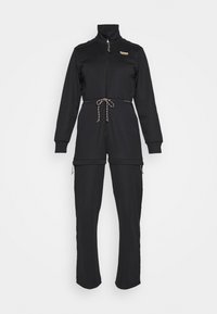 Černý overal s vysokým límcem, plným zipem, šňůrkou v pase a zipovými kapsami. Vyrobeno z hladkého, elastického materiálu.