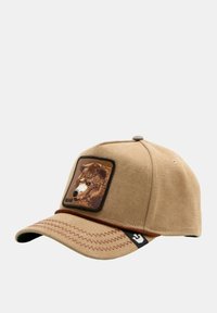 Gorra de béisbol color marrón claro con un parche texturizado de un oso en la parte frontal. Cuenta con una visera curvada, un detalle de costura en contraste y una etiqueta de logo en el lateral.
