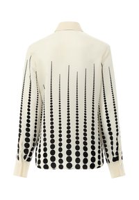 Blusa a maniche lunghe color crema con un motivo a gradiente di punti neri, dotata di colletto classico e polsini abbottonati, realizzata in tessuto dalla trama liscia.
