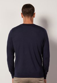 Marineblauer Langarmpullover mit Rundhalsausschnitt, glatter Textur und gerippten Bündchen, von hinten betrachtet. Einfaches Design, ohne Muster.