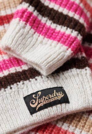 Uldhat med rosa, hvide og brune striber, med et struktureret ribbede design. Inkluderer et sort mærke med guldbroderi.