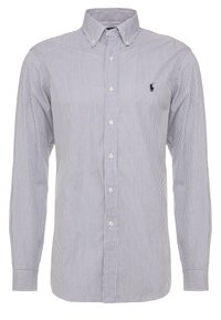 Skjorta med knappar framtill som har vertikala blå och vita ränder, långa ärmar och en liten broderad logotyp på vänster bröst.