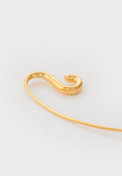 Złoty metalowy haczyk o falistym, kształcie litery S. Posiada gładką teksturę i błyszczące wykończenie, z lekko zaokrąglonym końcem.