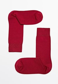 Røde bomuldsstrømper med et ensartet design. Sættet inkluderer en ribbet manchet og en glat tekstur, med afrundede tæer og mellemlang længde.