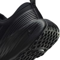 Baskets de sport noires avec une tige texturée et une semelle en caoutchouc avec un motif de semelle prononcé. Logo Nike subtilement affiché sur le côté.