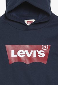 Sudadera de color marino con un gran logo rojo de Levi's® en texto blanco, confeccionada en una tela suave con un acabado texturizado y capucha con cordón.