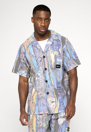 Kortærmet, knappet skjorte i et livligt flerfarvet mønster. Har en lomme, mørke knapper og tekstureret stof med abstrakte designs.