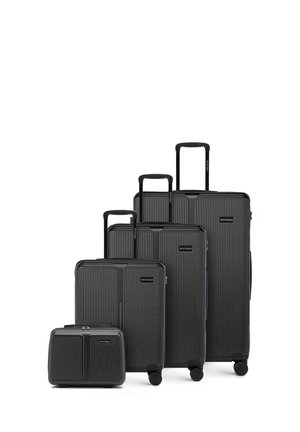 Vier schwarze Hartschalenkoffer in unterschiedlichen Größen mit Teleskopgriffen und Rollen, von klein nach groß angeordnet.