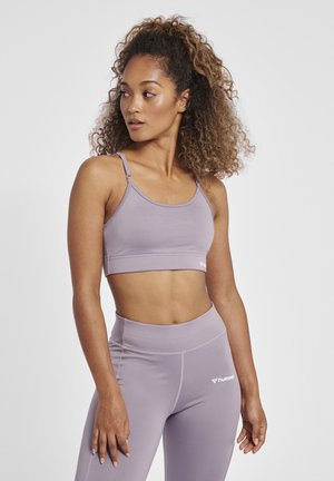 Hellblauer Sport-BH mit dünnen Trägern und einem Bund am unteren Ende. Kombiniert mit passenden, hoch taillierten Leggings mit dezentem Branding.