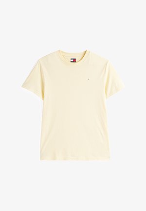 T-shirt de algodão de manga curta amarelo claro com pequeno logotipo da Tommy Jeans no lado esquerdo do peito e etiqueta da marca na parte interna do decote.