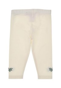 Cremefarbene Leggings mit elastischem Bund, mit grüner Blattstickerei an der unteren Seite jedes Beins. Weiches Baumwollmaterial, taillierte Passform.