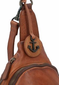 Borsa in pelle marrone con superficie testurizzata, caratterizzata da un'emblema di ancora nera e dettagli metallici sulla cerniera, tracolla resistente e forma arrotondata.