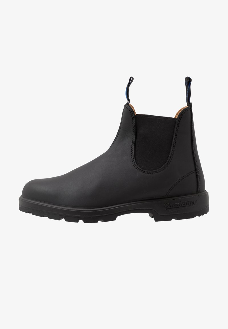 Bota Chelsea de cuero negro con paneles laterales elásticos, suela texturizada y dos lengüetas. Acabado suave y diseño de punta redonda.