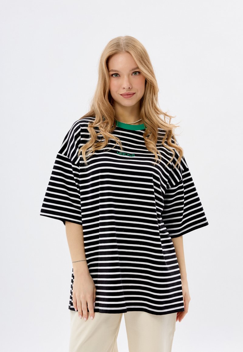 Zwart-wit gestreepte oversized t-shirt met een groene ribbelkraag en een klein groen logo. Korte mouwen en van zacht katoen.