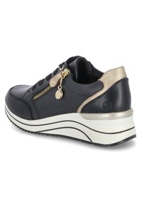 Baskets noires en cuir avec une finition texturée, accent doré sur le talon, fermeture éclair sur le côté et semelle blanche contrastante avec des lignes courbes.