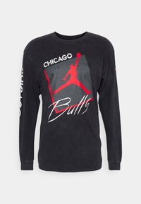 Svart långärmad t-shirt med en röd "Jumpman"-logotyp, "Chicago"-text och "Bulls"-skrift på en grå fyrkantig design. Tillverkad av bomull.