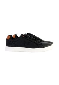 Zapatillas negras de material sintético con una suela de goma blanca, que presentan un acento marrón en el talón y cordones planos negros.