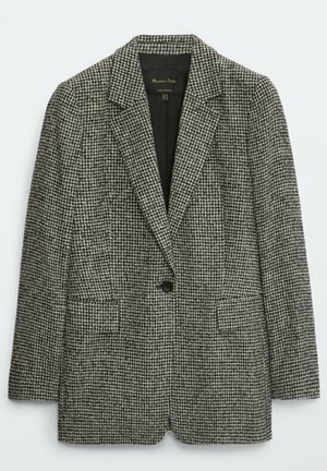 Blazer à carreaux gris et noir en tissu texturé, avec une fermeture à un bouton et deux poches avant. Design de revers classique.