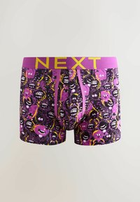 Bóxers morados con un divertido patrón de caras caricaturescas en negro y amarillo, con una cinturilla rosa brillante etiquetada con "NEXT" en amarillo.