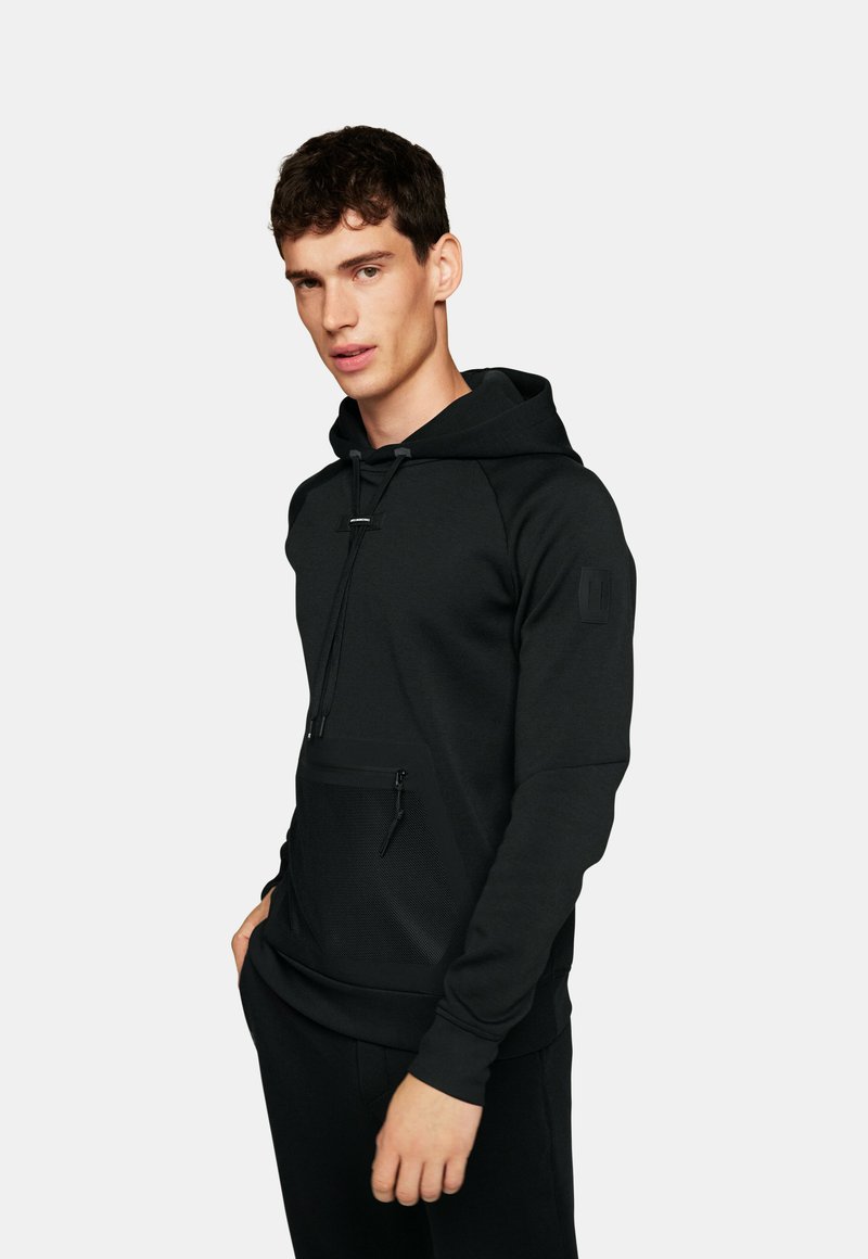 Hoodie noir avec une poche zippée à l'avant, capuche avec cordon de serrage et manches raglan. Tissu lisse avec une poche en mesh texturé en accent.