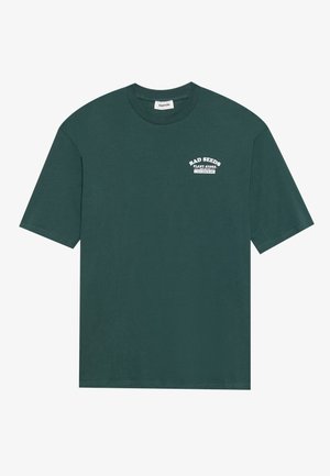 Donkergroen katoenen T-shirt met korte mouwen en een ronde hals. Voorzien van witte tekstprint: "BAD SEEDS PLANT STORE" op de borst.