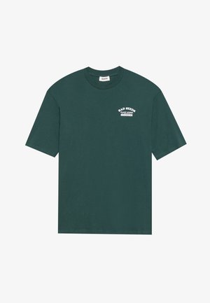 Mørkegrønn bomull T-skjorte med korte ermer og rund hals. Har hvit teksttrykk: "BAD SEEDS PLANT STORE" på brystet.