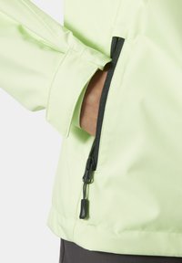 Chaqueta verde claro con una textura suave y un bolsillo con cremallera lateral. Presenta puños elásticos y un dobladillo recto para un ajuste ceñido.