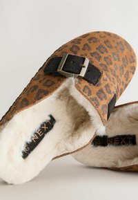 Leopardenmuster Hausschuhe mit braunem Wildleder-Obermaterial, schwarzem Riemen und Schnalle sowie weichem weißen Kunstpelzfutter. Abgerundete Zehenform.