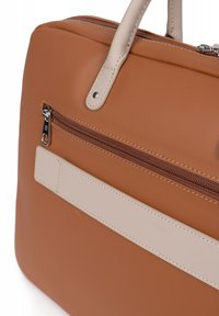 Bruine textuurstof tas met lichtbeige accenten, voorzien van een ritszak en twee handvatten. Het ontwerp bevat een gladde band en stikdetails.
