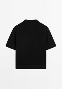 Mustapaita lyhyillä hihoilla, jossa on pehmeä rakenne, ribattu kaulus ja siistit linjat. Yksinkertainen, nykyaikainen muotoilu ilman ylimääräisiä koristeita.