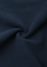 Tessuto di pile blu scuro con una superficie morbida e testurizzata, che mostra una piega a spirale. Il materiale appare caldo e spesso con un colore uniforme.