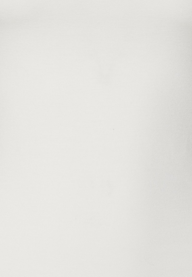 Biały dopasowany top na ramiączkach wykonany z gładkiej, elastycznej bawełny, z okrągłym dekoltem i bezszwowym designem. Brak widocznych wzorów lub akcentów.