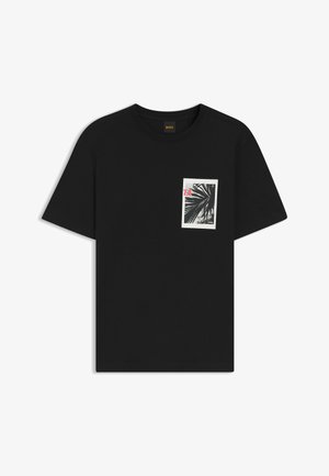 T-shirt noir à manches courtes avec col rond, présentant une petite photo en noir et blanc d'une feuille de palmier et un texte rouge "7.8" sur le côté gauche de la poitrine.
