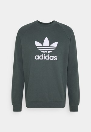Ciemnozielona bluza Adidas z długim rękawem z białym logo Trefoil i napisem "adidas" na środku klatki piersiowej.