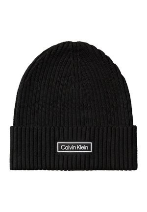 Black ribbed knit beanie with folded cuff and white rectangular Calvin Klein logo patch on front center.