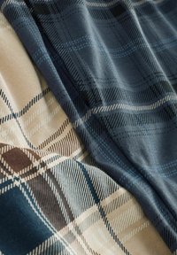 Karo-Stoffe in Blau-, Beige- und Brauntönen, mit glatten Texturen und detaillierten Karomustern sowie kontrastierenden Linien.
