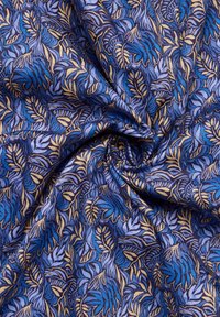 Katoenen stof met een levendig blauw en goud bladpatroon. Gladde textuur met ingewikkelde details en een vloeiend ontwerp.