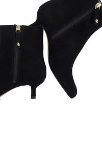 Black suede ankle boots with a pointed toe, zip closure, and a small stiletto heel; features gold-tone hardware accents.