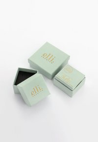Mintgroene papieren geschenkbdozen met gouden accenten. Eén doos is iets open, waardoor een zwarte binnenkant zichtbaar is. De tekst bevat "elli. PREMIUM."