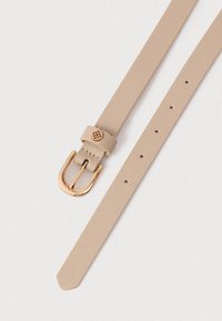 Μπεζ ζωνάκι με υφή, με χρυσό μεταλλικό κούμπωμα και διακοσμητικό κλιπ για τη ζώνη. Διαθέτει τρύπες για ρύθμιση μεγέθους.