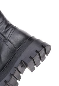 Bota de cuero negro con parte superior texturizada, punta redondeada y suela de goma gruesa que presenta estrías prominentes para mayor tracción.