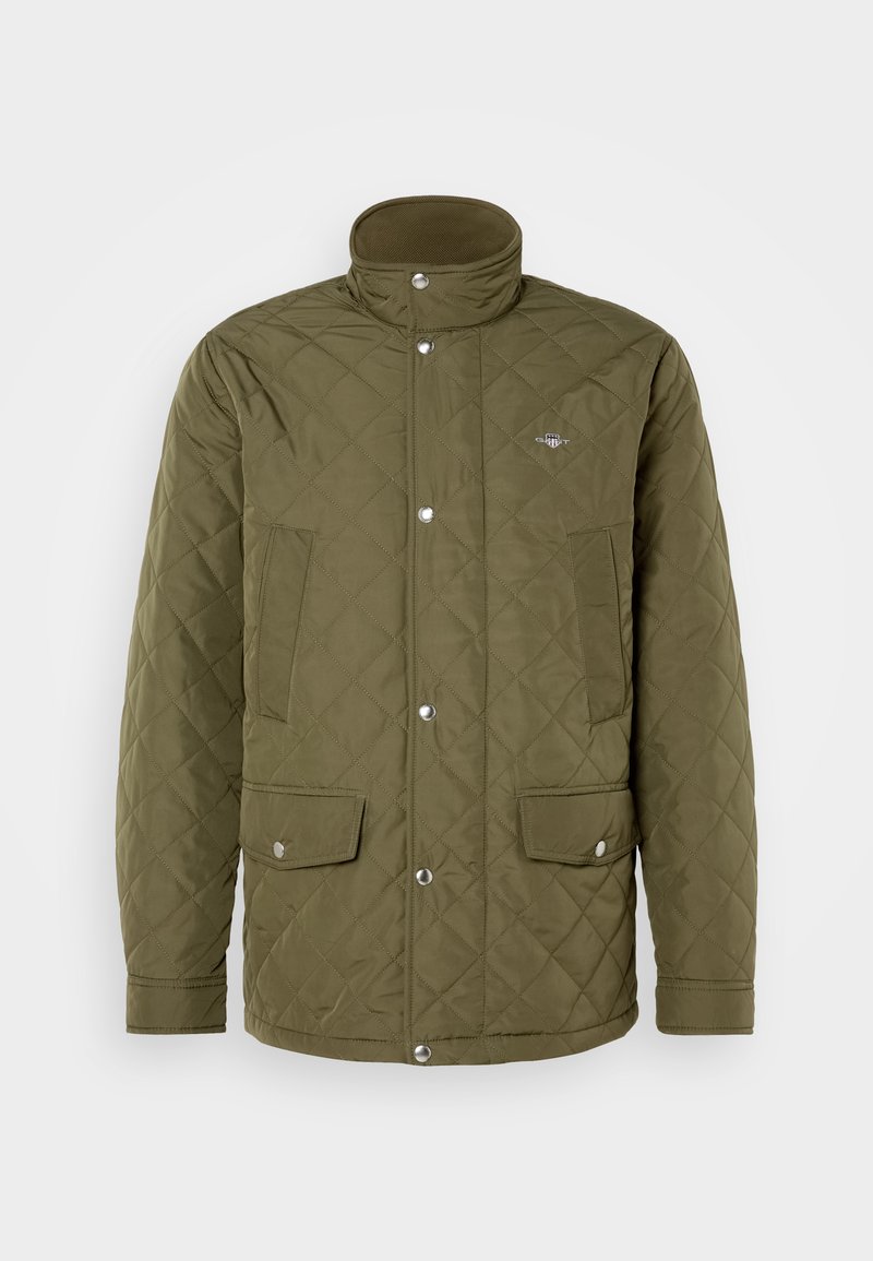 Oliwkowa wypchana kurtka z wysokim kołnierzem, zatrzaskami oraz dwiema przednimi kieszeniami. Tkanina ma gładką teksturę z wykończeniem w romby.