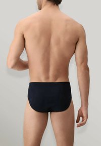 Pantaloni da bagno blu navy realizzati in tessuto liscio e elastico, con vita moderata e una cintura elastica sicura.