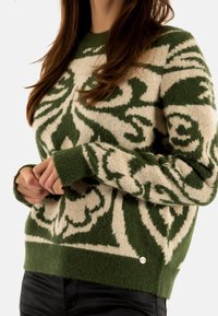 Maglione lavorato a maglia caratterizzato da un motivo floreale verde e beige, scollo rotondo, polsini e orlo a costine, realizzato in un materiale morbido e textured.