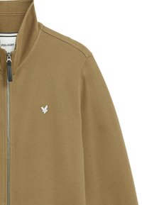 Giacca zip-up marrone con un tessuto testurizzato, caratterizzata da un colletto alto e un piccolo logo di aquila bianco sul petto. Dettagli con zip argentata.