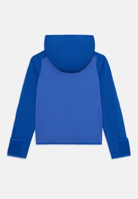 Veste à capuche bleue en tissu texturé, avec des panneaux d'épaules contrastants et des poignets. Design simple et fonctionnel.